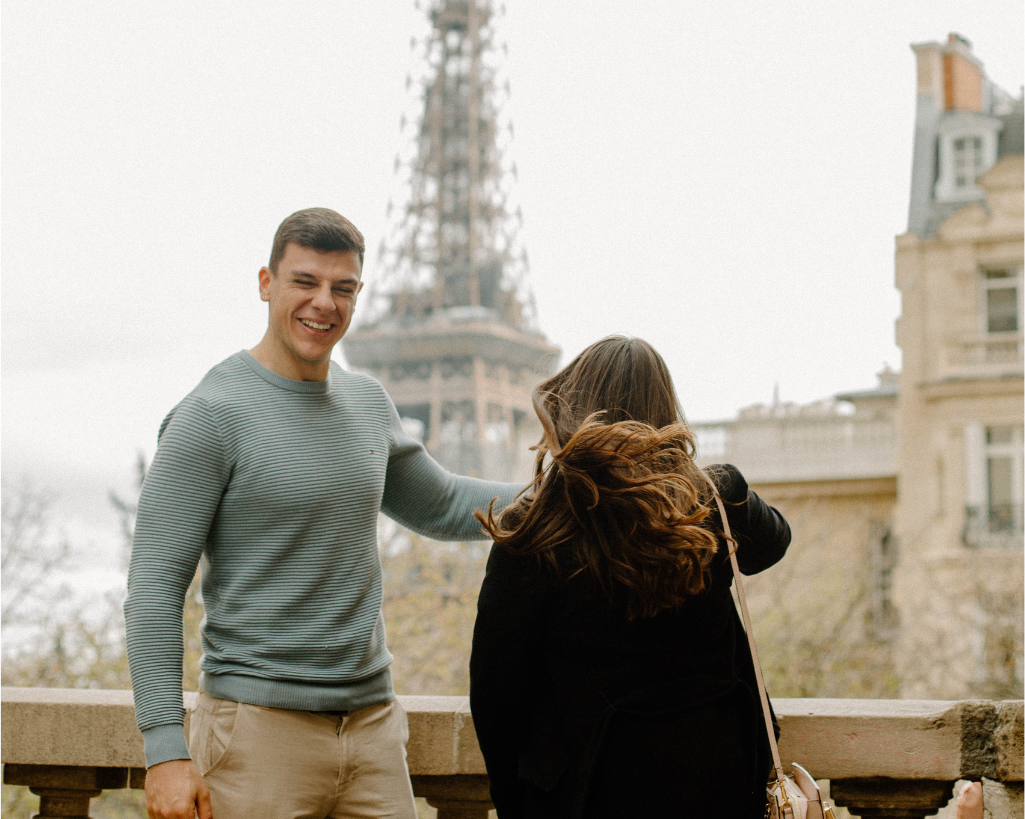 Boyfriend spinning girlfriend underneath the Eiffel Tower