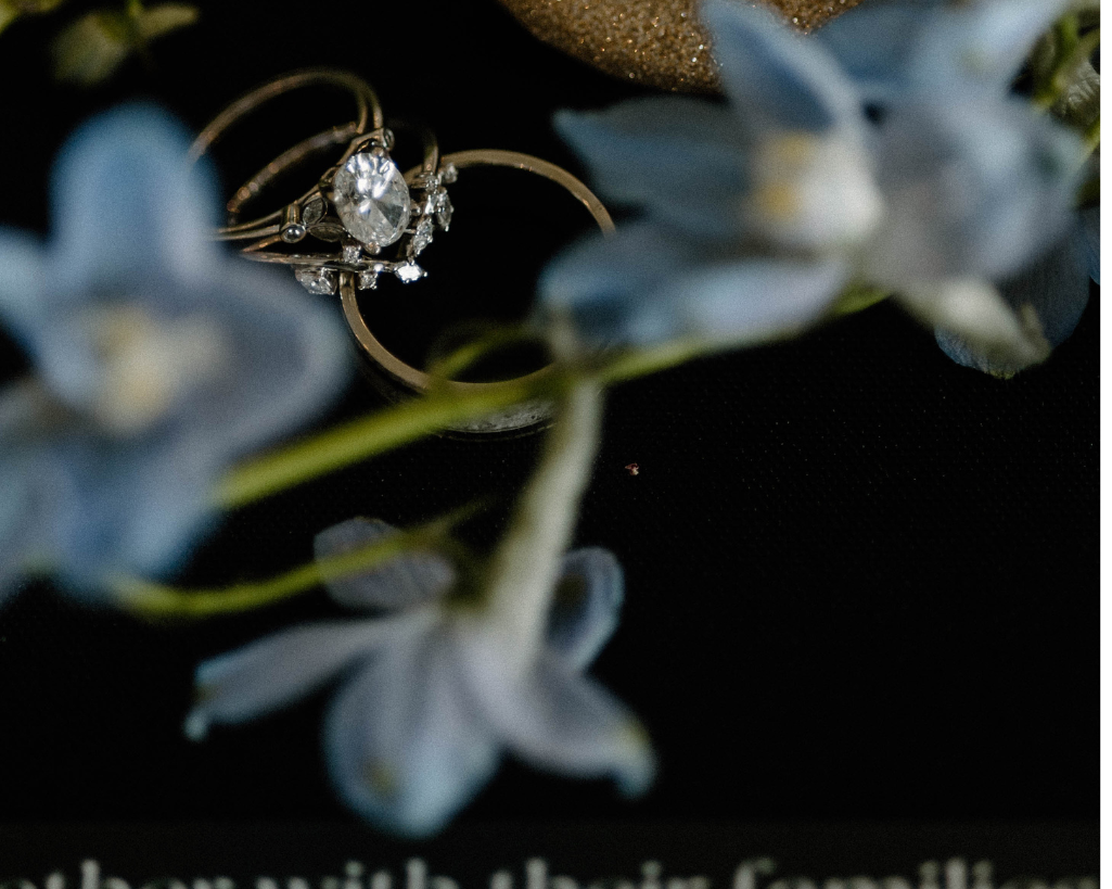 Wedding detail shot with wedding rings and blue flowers