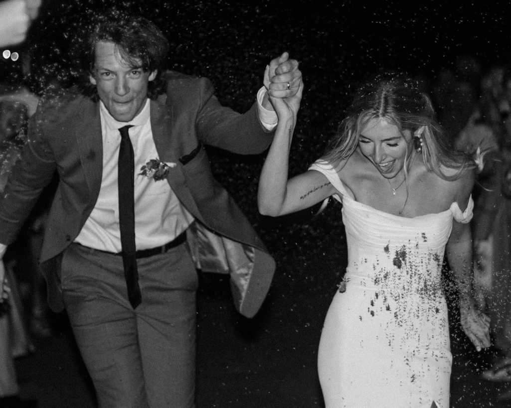 Bride and groom run joyfully through a lavender toss grand exit. 