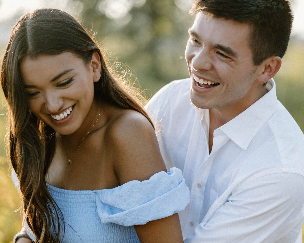 Couple laughs joyfully as they hug in playful photography session