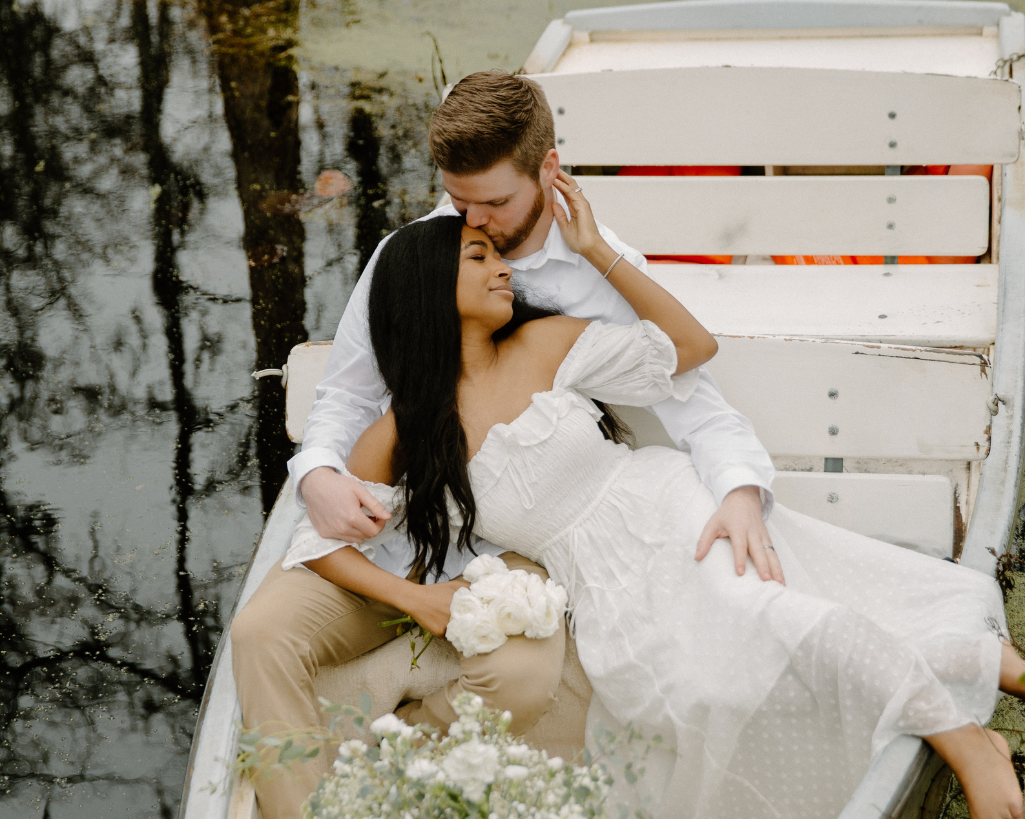 Bride lays against groom on boat at cypress gardens