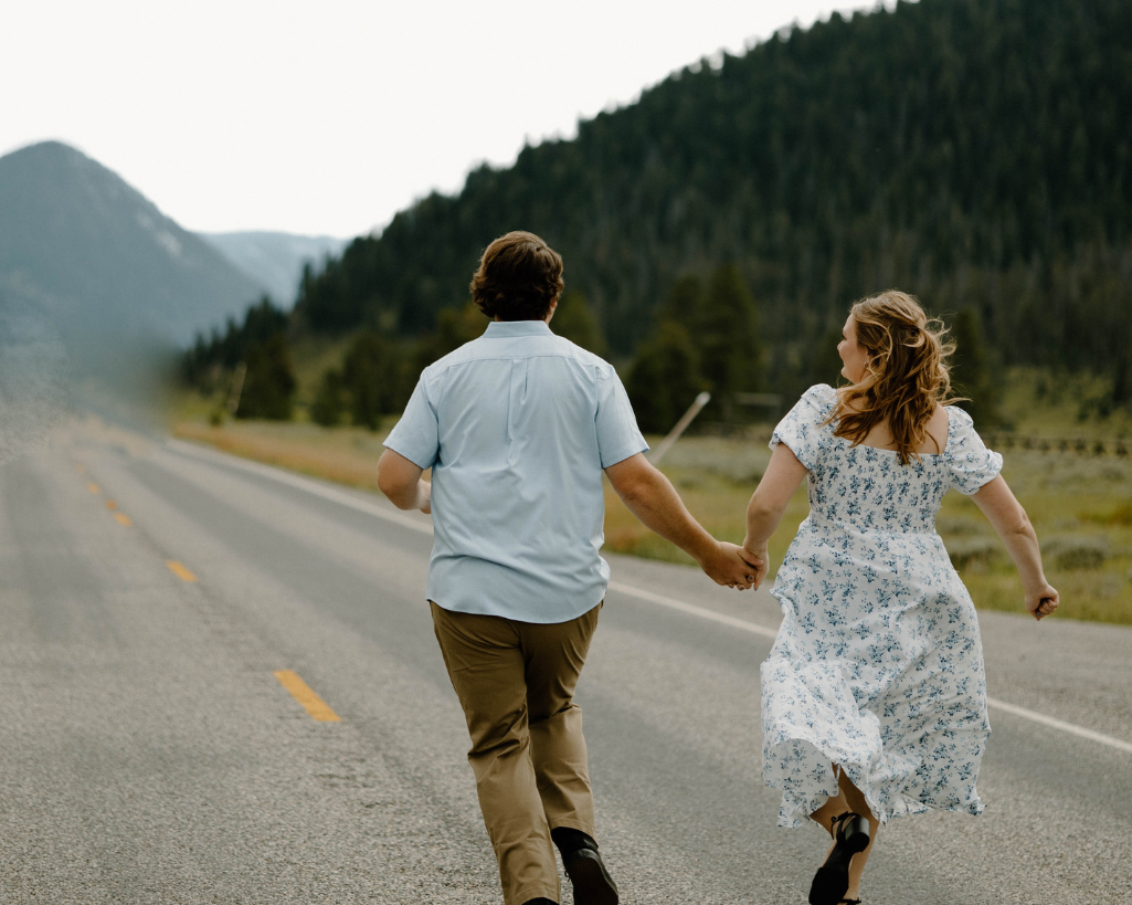 Engaged couple running down Montana rode