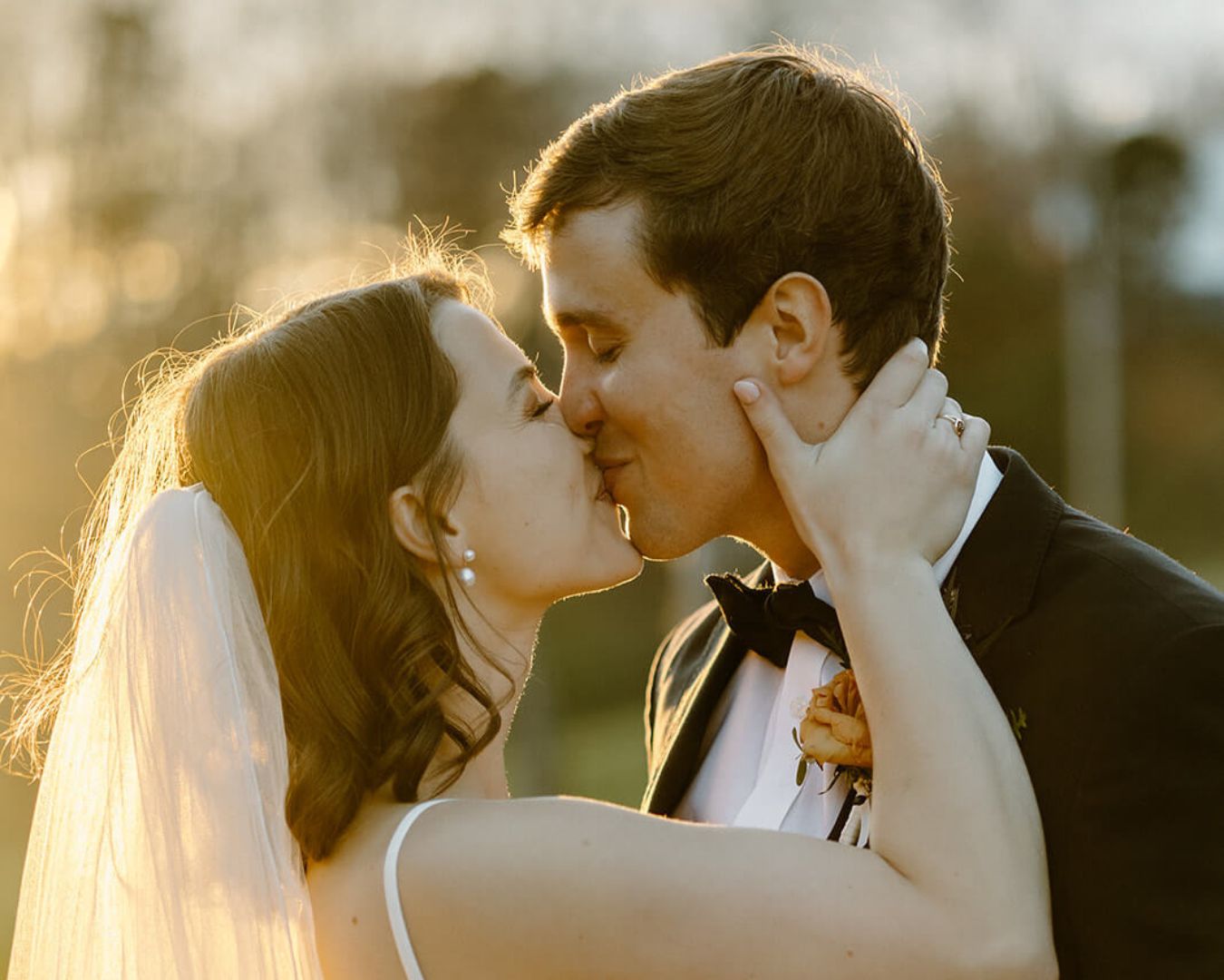 Bride and groom kiss in the glow of a North Carolina sunset.