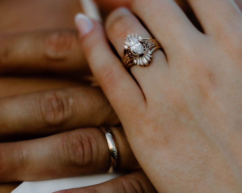Close up image of bride's wedding ring as she interlaces her hand in the groom's
