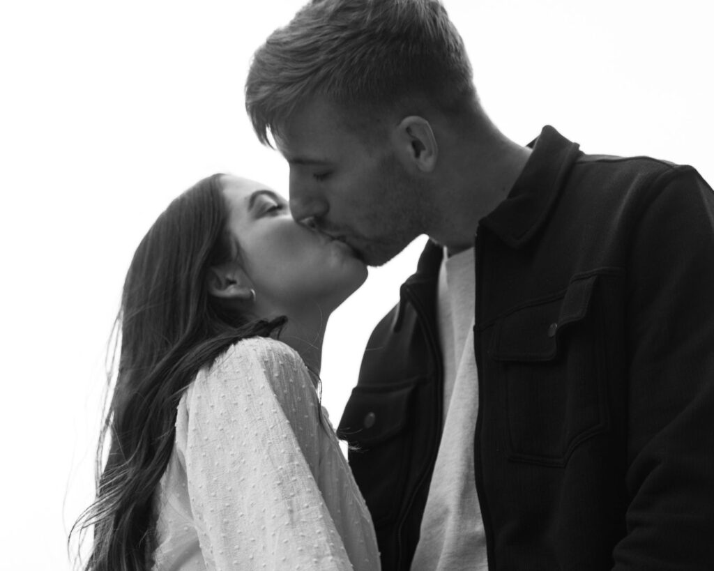 Romantic, black and white photograph of man and woman kissing.