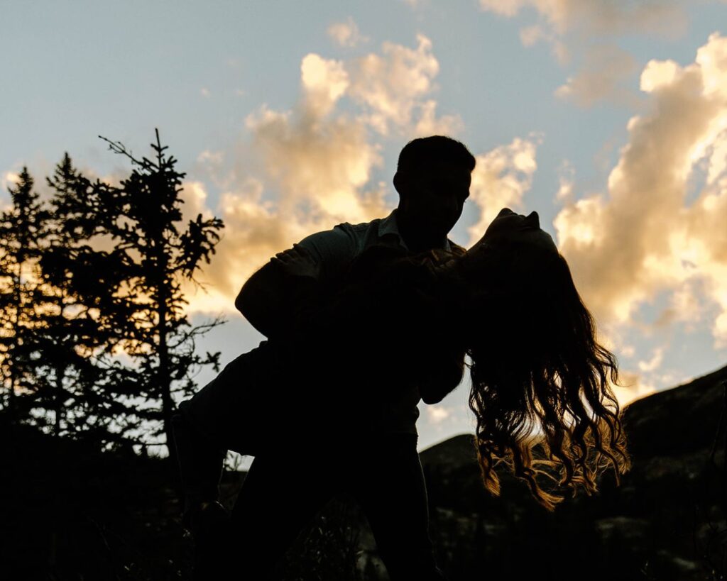 Stunning mountain sunset casts dancing couple in shadow