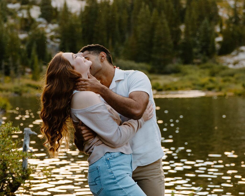 Woman laughs as man kisses her cheek