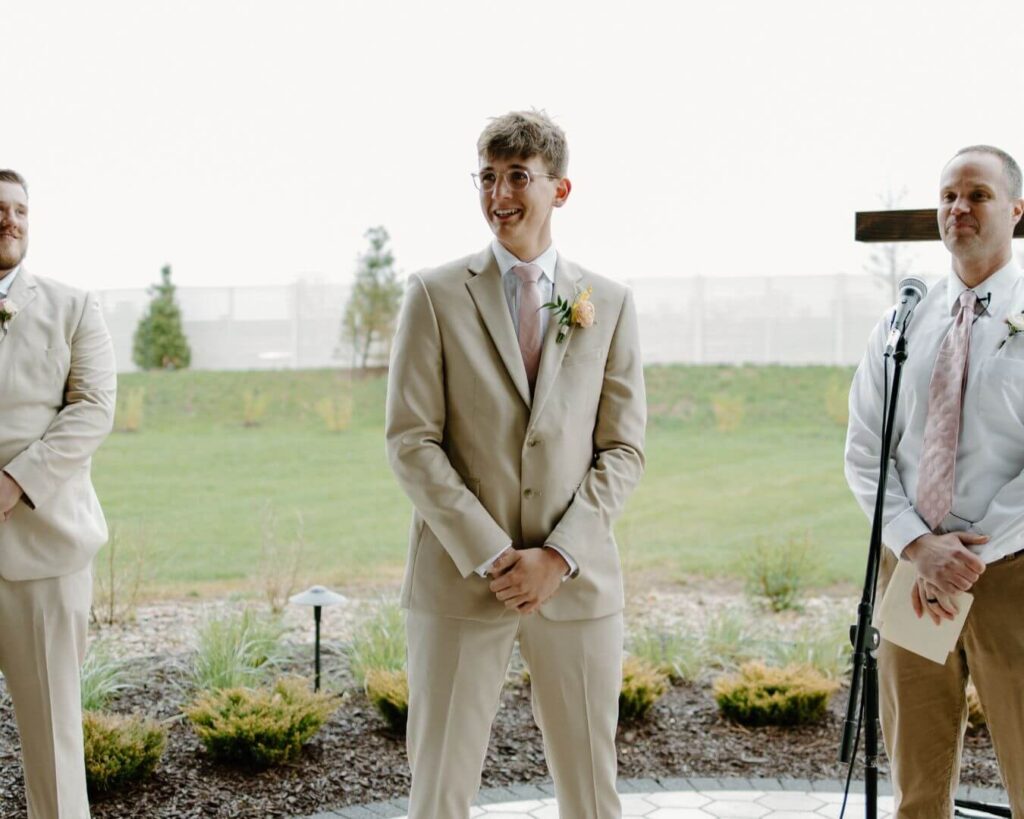 Groom tears up as bride comes down the aisle in spring wedding in Iowa.