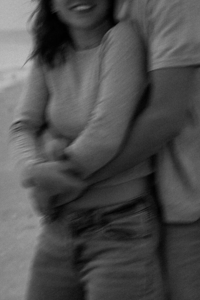 Blurry black and white photo of couple in embrace in adventure engagement photoshoot.