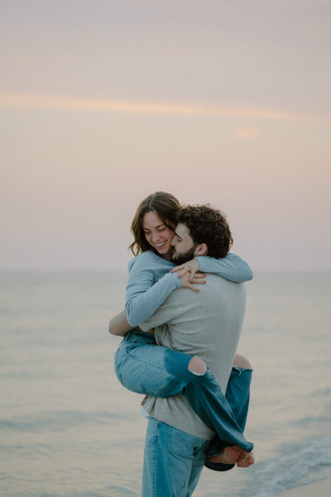 Couple twirls around Sanibel Island beach in adventure engagement photoshoot.