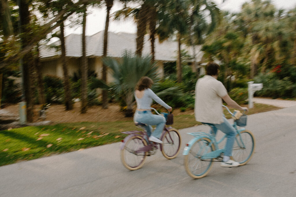 Couple rides bikes together down the streets of Sanibel Island in adventure engagement session