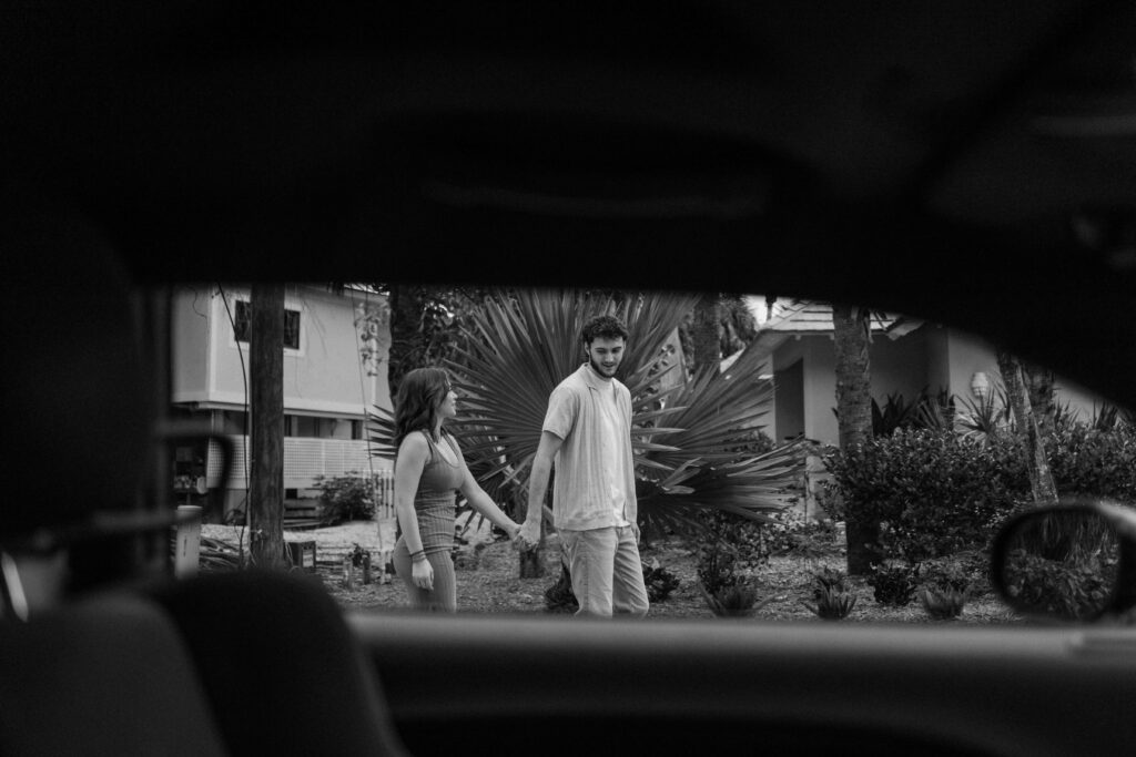 Photo through car window of couple walking down the streets of Sanibel Island, Florida.
