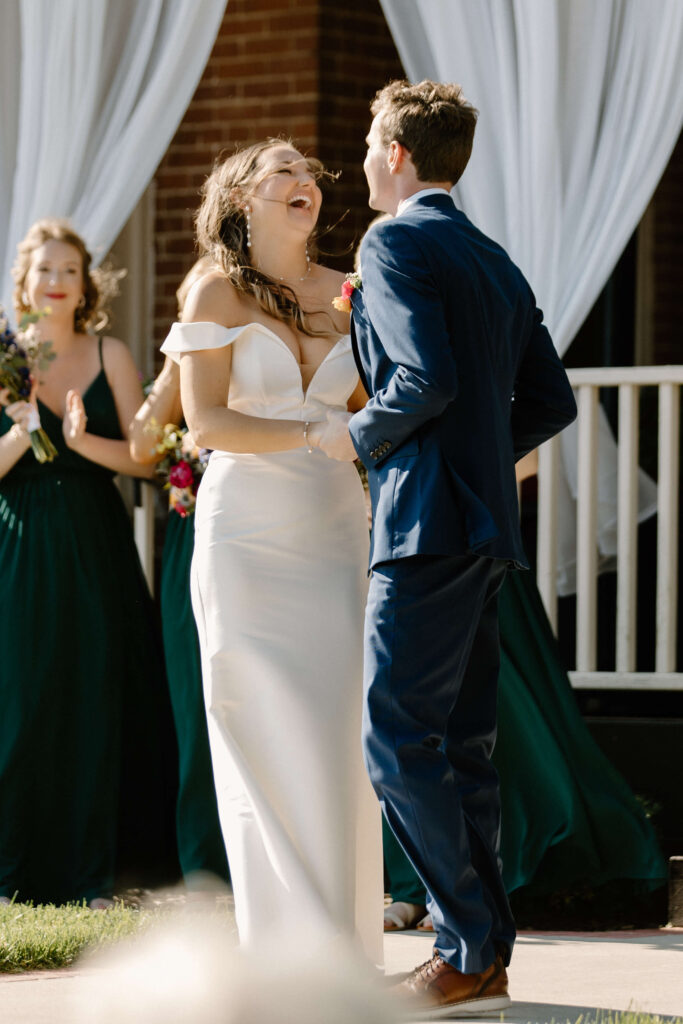 Bride laughs exuberantly at something groom said to her