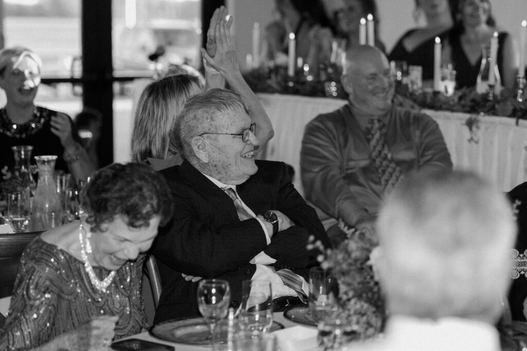 Grandparents laugh at a wedding reception speech