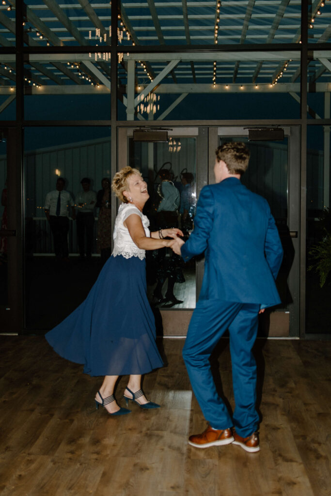 Mother of the groom and groom dance joyfully together