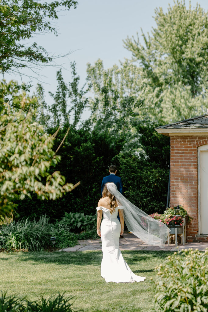 Bride approaches groom during backyard first look in documentary-style wedding photography