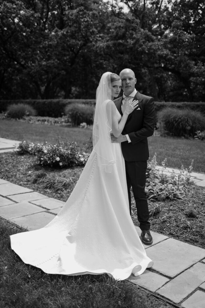 Bride and groom pose and look at the camera in dramatic couples portrait