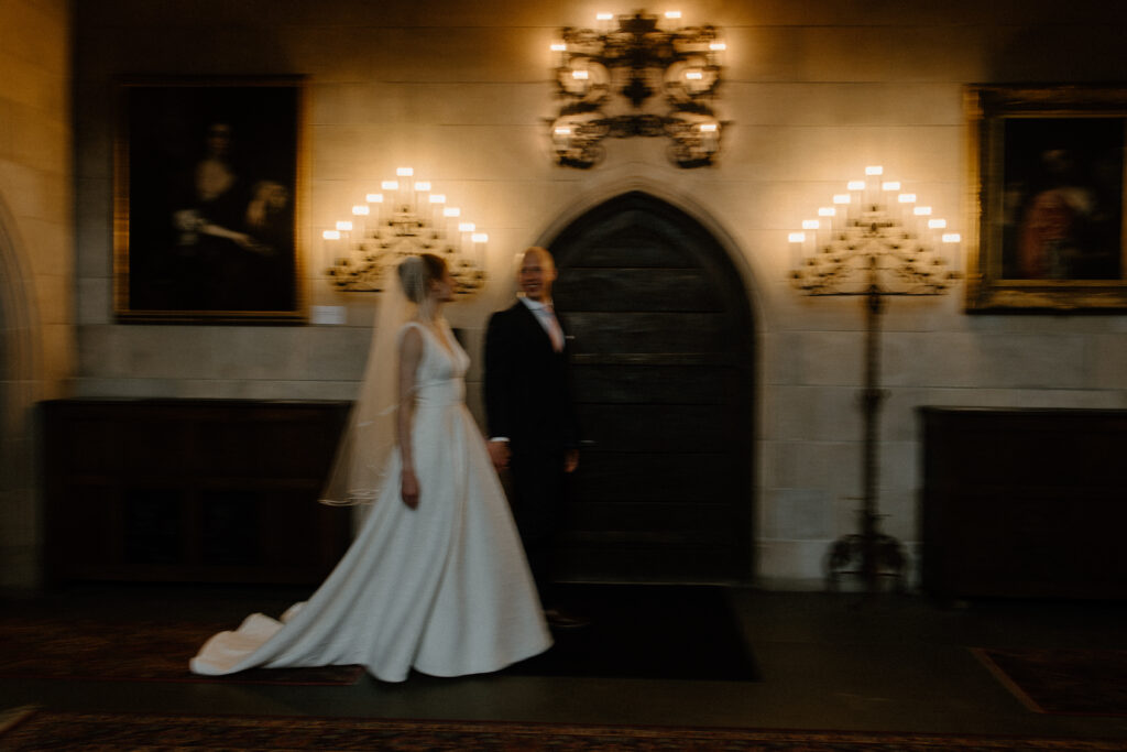 Bride and groom walk through the romantic, moody halls of Salisbury House and Gardens