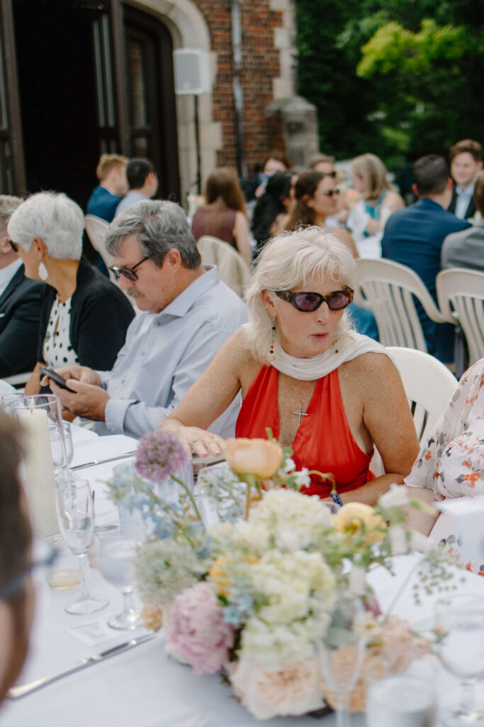 Garden wedding guest speaks with other people at her table