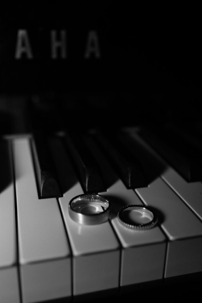 Bride and groom's wedding rings lay on Yamaha piano keys