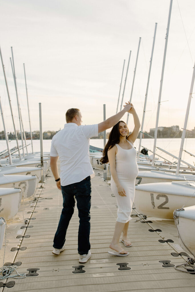 Man twirls expecting woman on dock of Bde Mka Ska marina. 