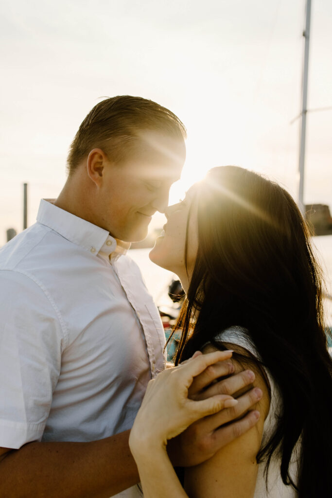 Man and woman go in for a kiss as the sun sets behind them along the Minneapolis skyline.