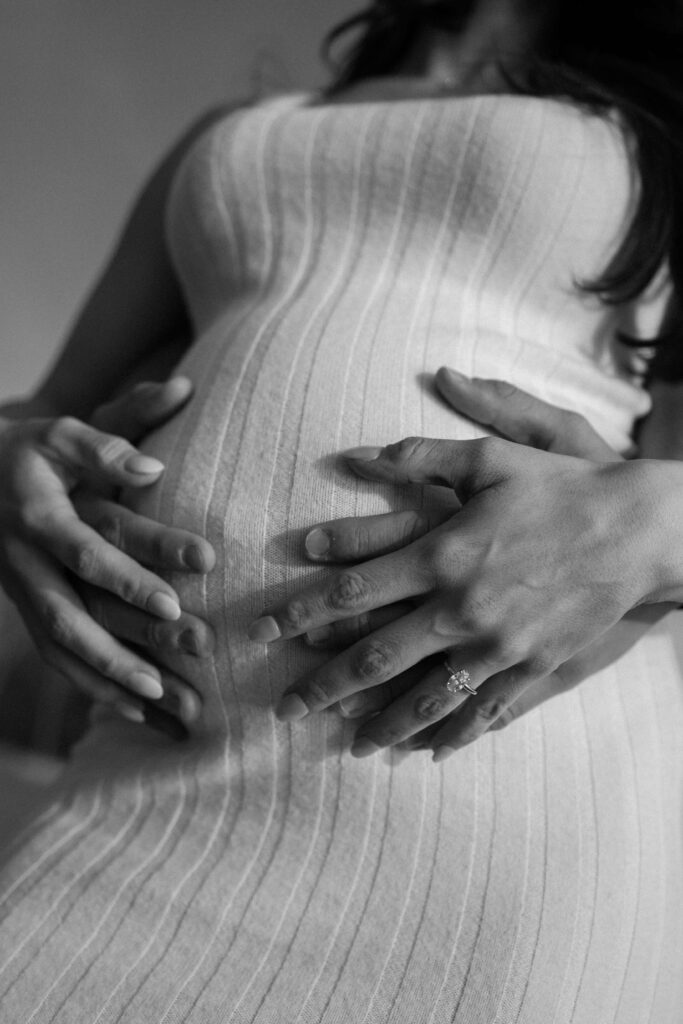 Man and woman hold pregnant belly